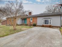 Single-story brick home featuring a concrete driveway and a quaint front yard at 1525 Oakridge Dr, Salisbury, NC 28146
