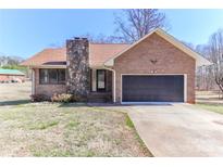 Charming brick home featuring a stone chimney, attached garage and cozy front yard at 2274 Old Wilkesboro Rd, Statesville, NC 28625