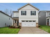 Charming two-story home featuring a white garage door, neutral siding and manicured landscaping at 302 Bezelle Ave, York, SC 29745