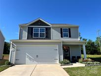 Charming two-story home boasts a two-car garage, covered porch, and lovely curb appeal at 329 Aniston Ln, Shelby, NC 28152