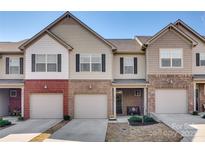 Charming townhome features a brick facade, one-car garage, and well-manicured landscaping at 5212 Spanish Ivy Ln, Indian Land, SC 29707