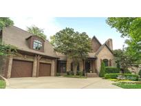 Elegant brick home showcasing a well-manicured lawn and a spacious three-car garage at 5523 Closeburn Rd, Charlotte, NC 28210