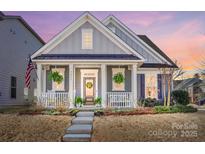 Charming home featuring a welcoming front porch, beautiful landscaping, and a well-maintained yard at 7035 Walnut Branch Ln, Charlotte, NC 28277
