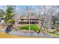 Multi-level brick home with a spacious deck overlooking the landscaped yard and waterfront at 11 Courageous St, Lake Wylie, SC 29710