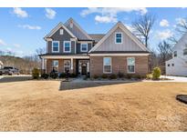 Charming two-story home featuring a brick and siding exterior with a well-maintained front lawn at 17215 Monocacy Blvd, Huntersville, NC 28078