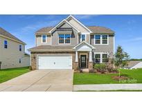 Charming two-story home featuring stone accents, a two-car garage, and a well-manicured front lawn at 6265 Fairfax Ct, Maiden, NC 28650