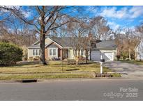Charming single-story home featuring brick accents, attached two-car garage and well-maintained landscaping at 13015 Greycrest Dr, Charlotte, NC 28278