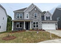 Charming two-story home featuring a stone facade, a two-car garage, and manicured front lawn at 173 Glenn Dr, Mooresville, NC 28115