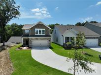 Two-story home featuring a two-car garage and a well-manicured front lawn at 2005 White Cypress Ct # Kh12, Charlotte, NC 28216