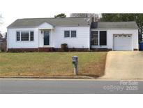 Charming single-story home with a tidy front lawn and attached garage, showcasing curb appeal at 216 Park Ridge Rd, Albemarle, NC 28001