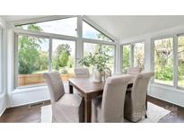 Sunlit dining area with large windows, a wooden table, and upholstered chairs at 236 Victoria Ave, Charlotte, NC 28202