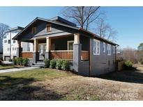 Charming craftsman home featuring a welcoming front porch with wooden railings, and lush landscaping at 236 Victoria Ave, Charlotte, NC 28202