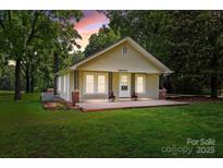 Charming single-story home featuring a welcoming front porch, manicured lawn, and mature trees at 28419 Nc Hwy 73 Hwy, Albemarle, NC 28001