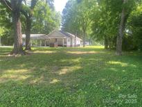 Charming single-story home with a covered carport and a well-maintained, spacious front yard surrounded by mature trees at 28419 Nc Hwy 73 Hwy, Albemarle, NC 28001