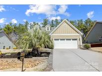 Charming single-Gathering home with a manicured lawn, palm tree, and an attached two-car garage at 5252 Admirals Lndg, Lancaster, SC 29720