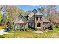 Charming two-story home with manicured lawn, brick facade and arched entryway at 6548 Robin Hollow Dr, Mint Hill, NC 28227
