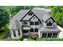 Stunning traditional-style home boasts a manicured lawn, brick exterior, and elegant black accents at 8707 Fairview Rd, Charlotte, NC 28226