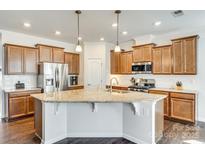 Gourmet kitchen with stainless steel appliances, granite counters, and dark wood cabinets at 10014 Berkeley Castle Dr, Charlotte, NC 28273