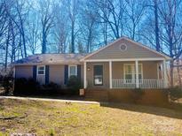 Charming single-story home featuring a cozy front porch and mature trees at 105 Old Bridge Ct, Gastonia, NC 28056