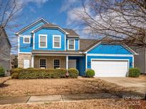 Charming blue two-story home with stone accents, attached garage, and manicured landscaping at 10826 Saltmarsh Ln, Charlotte, NC 28278