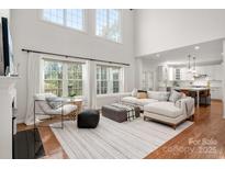 Bright living room featuring hardwood floors, large windows, and comfortable seating arrangement at 11001 Valley Spring Dr, Charlotte, NC 28277