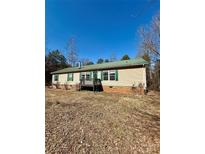 Charming single-story home with a metal roof, green shutters, and a cozy front porch at 191 Ashford Dr, Olin, NC 28660