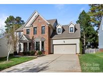 Charming two-story brick home featuring a two-car garage, bay window, and well-maintained landscaping at 19933 Scanmar Ln, Cornelius, NC 28031