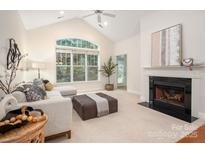 Inviting living room features a fireplace, large window, and plush seating, creating a cozy atmosphere at 2941 Bellasera Way, Matthews, NC 28105