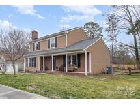 Charming two-story home with a welcoming front porch and well-maintained landscaping at 307 Matthews Crossing Dr, Matthews, NC 28105