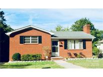 Charming brick home featuring black shutters, a manicured lawn, and a cozy front entrance at 321 14Th St, Salisbury, NC 28144