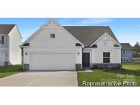 New construction home featuring a two-car garage, craftsman style accents, and a manicured lawn at 40189 Crooked Stick Dr # 1205, Lancaster, SC 29720