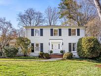 Charming, two-story home with white painted brick, black shutters, and mature landscaping at 555 Manning Dr # 7, Charlotte, NC 28209