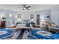 A serene bedroom features a comfortable bed, soft blue accents, and an inviting chaise lounge, creating a relaxing retreat at 7520 Pleasant Hill Church Rd, Marshville, NC 28103