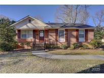 Charming brick home with manicured lawn and walkway leading to the front door at 7526 Dorn Cir, Charlotte, NC 28212