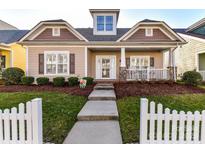 Charming home with a welcoming front porch, manicured lawn, and a white picket fence at 1012 Preakness Blvd, Indian Trail, NC 28079