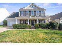 Charming two-story home with manicured lawn, trimmed hedges and welcoming front porch at 11711 Royal Castle Ct, Charlotte, NC 28277