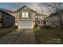 Inviting two-story home with a two-car garage, lush lawn, and inviting landscaping at 15320 Yellowstone Springs Ln, Charlotte, NC 28273