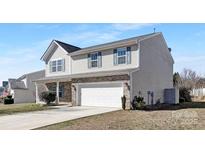 Charming home showcasing its brick and vinyl exterior, featuring a two-car garage and well-maintained lawn at 1612 Beleek Ridge Ln, Clover, SC 29710