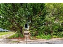 Charming home featuring mature trees, front entry stairs and a lush garden surrounding the pathway to the front door at 1716 Umstead St, Charlotte, NC 28205