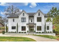 Stunning white brick home with a manicured lawn and a modern architectural design, embodying luxury living at 229 N Canterbury Rd, Charlotte, NC 28211