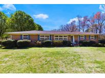 Charming single-story brick home featuring blue shutters and a well-maintained front lawn and mature landscaping at 4937 Lebanon Dr # 1, Charlotte, NC 28273