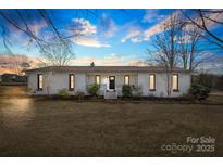 Beautifully landscaped one story home with modern exterior lighting at 702 Shearers Rd, Mooresville, NC 28115