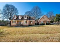 Charming exterior view of a well-maintained home with brick and siding, dormer windows and a spacious front yard at 133 Persimmon Creek Rd # 81, Kings Mountain, NC 28086