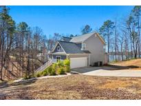 Gray two-story home with an attached two-car garage on a large lot with lake access at 13701 Petworth Ct, Charlotte, NC 28278