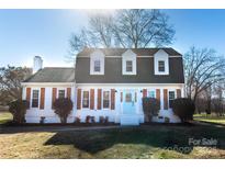 Charming two-story home featuring a light blue front door, dormer windows, and a well-manicured front yard at 2918 Medlin Rd, Monroe, NC 28112