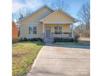 Charming yellow cottage with a cozy front porch and well-manicured lawn on a sunny day at 293 Blanche Cir, Rock Hill, SC 29730