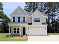 Charming two-story home featuring a two-car garage and a beautifully maintained front yard at 338 Shinnville Rd, Mooresville, NC 28115