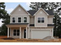 Two-story home with a two car garage, board and batten siding and a covered front porch with columns at 338 Shinnville Rd, Mooresville, NC 28115