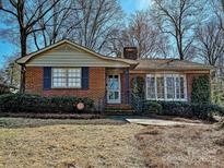 Charming brick home with a well-maintained lawn and mature trees, offering classic curb appeal at 410 Moncure Dr, Charlotte, NC 28209