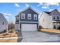 Charming two-story home showcasing a well-manicured lawn and a driveway leading to a two-car garage at 5010 Arbordale Way # 5, Mount Holly, NC 28120